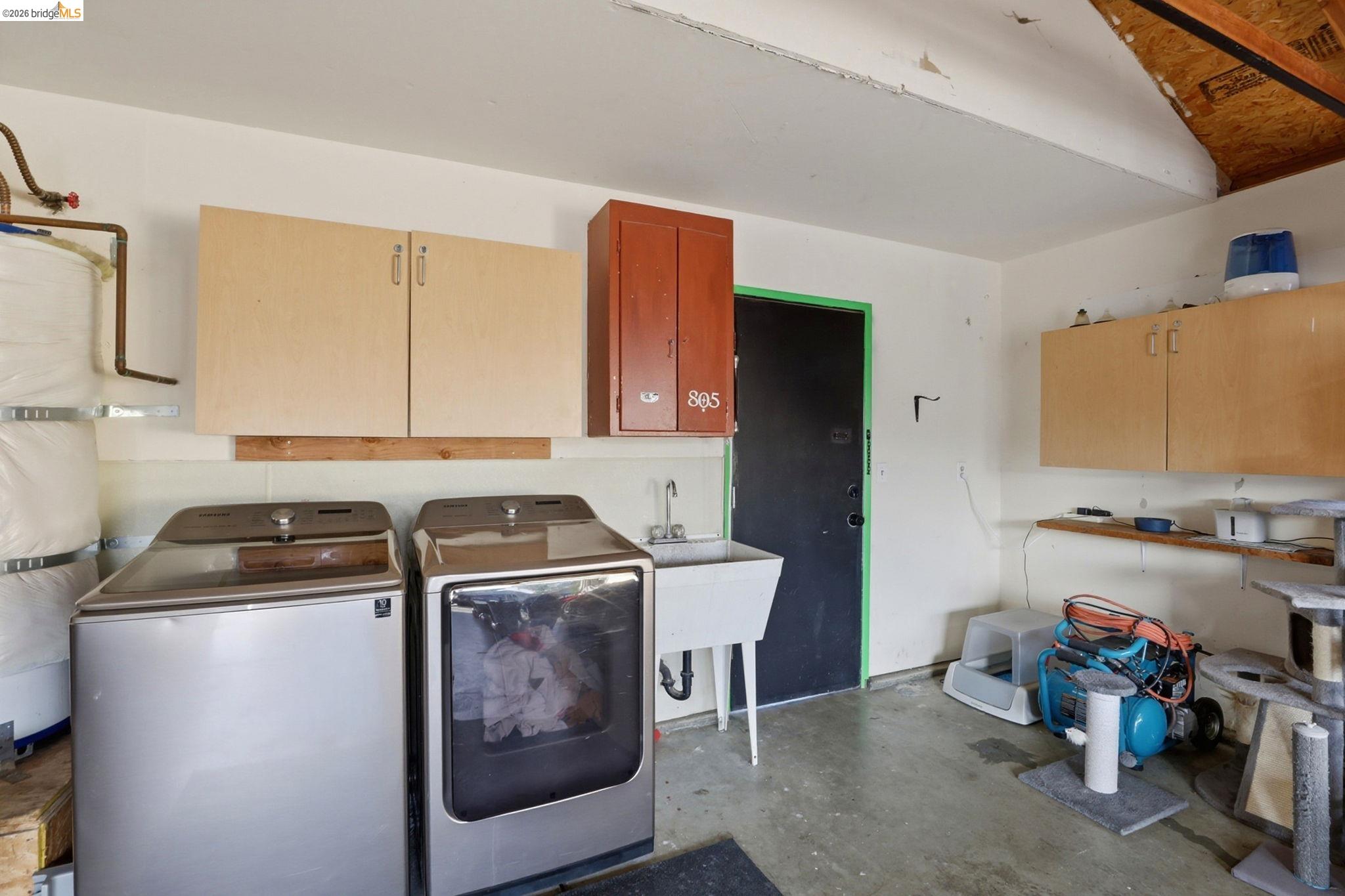 799 Morgans Ranch Circle Galt, CA 95632 - Photo 29 of 36 Laundry room with unfinished concrete flooring, water heater, independent washer and dryer, and cabinet space
