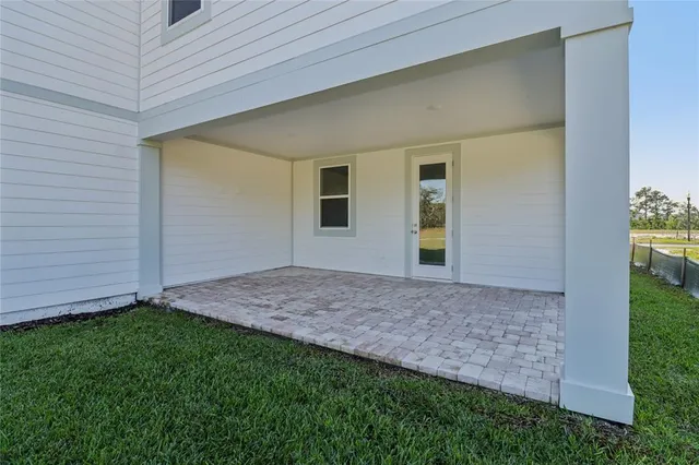 a backyard of a house with barbeque oven table and chairs