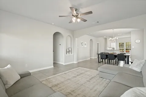 a living room with furniture and a dining table with kitchen view