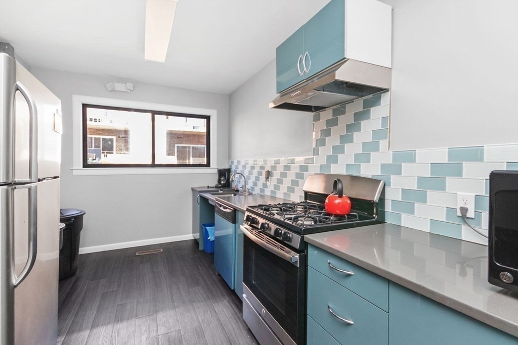 55 Broadlawn Park, Unit 11B Boston, MA 02467 - Photo 22 of 25 a kitchen with stainless steel appliances granite countertop a stove sink and cabinets