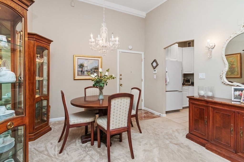 55 Broadlawn Park, Unit 11B Boston, MA 02467 - Photo 4 of 25 a dining room with furniture a chandelier and wooden floor