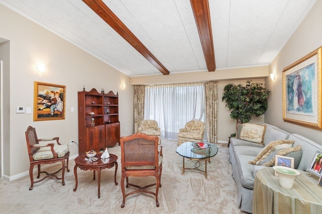 55 Broadlawn Park, Unit 11B Boston, MA 02467 - Photo 9 of 25 a living room with furniture and a large window