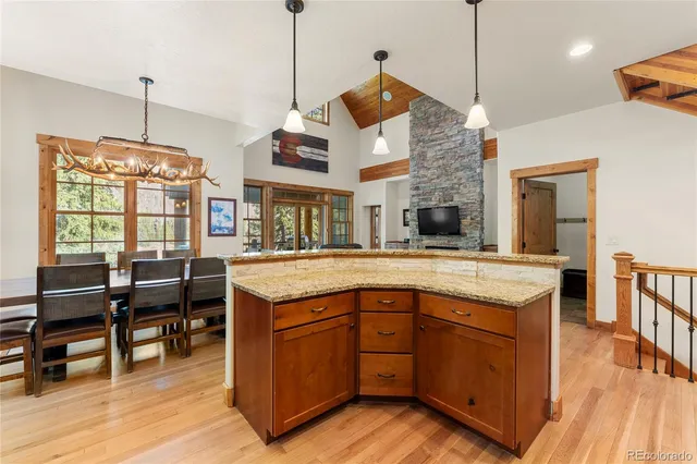 a kitchen with stainless steel appliances granite countertop a stove and a wooden floor
