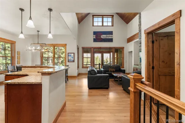 a view of a kitchen with kitchen island granite countertop a large counter space a sink appliances and cabinets