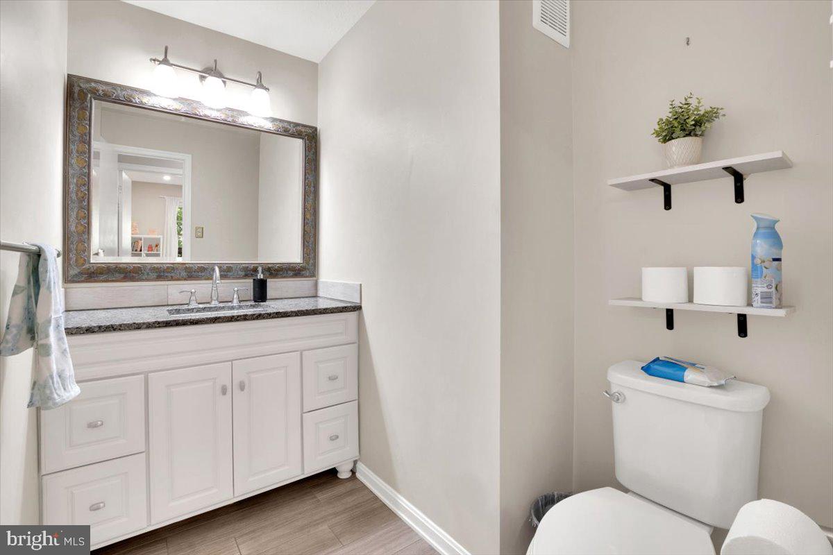10096 Oakton Terrace Road, Unit 10096 Oakton, VA 22124 - Photo 22 of 24 a bathroom with a granite countertop sink mirror and toilet