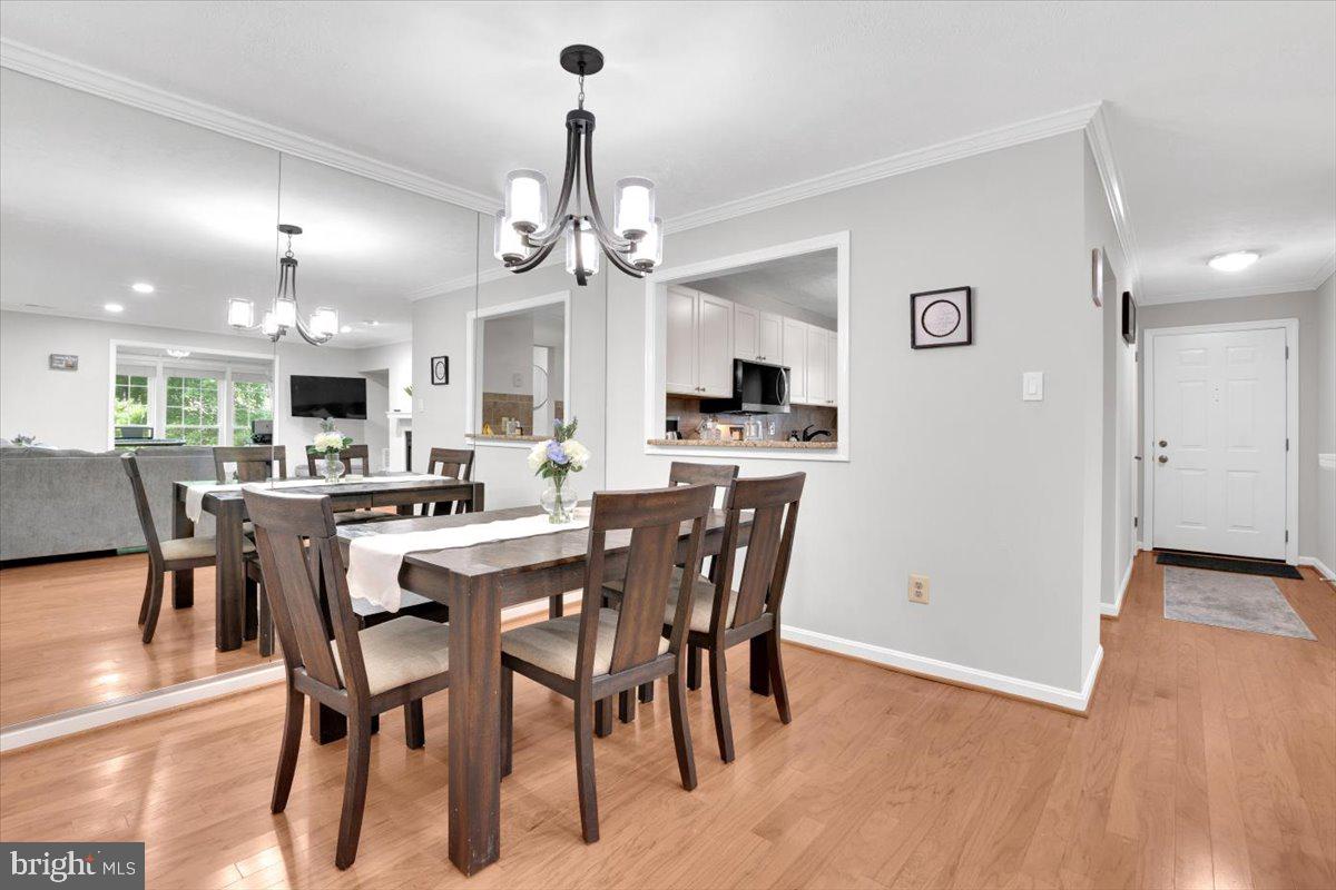 10096 Oakton Terrace Road, Unit 10096 Oakton, VA 22124 - Photo 9 of 24 a view of a dining room and livingroom with furniture wooden floor a chandelier