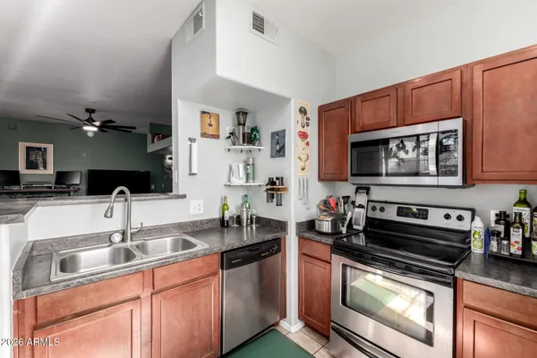 a kitchen with stainless steel appliances a sink a stove a microwave a sink and cabinets