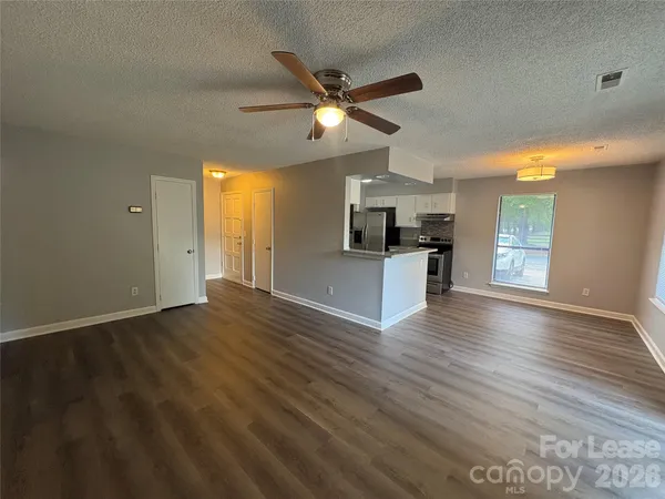 wooden floor in an empty room with a kitchen