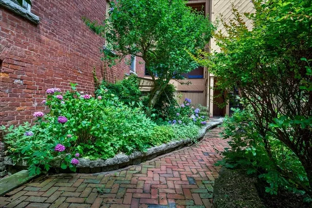 a view of a house that has a flower garden