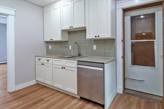 a kitchen with granite countertop white cabinets and white appliances