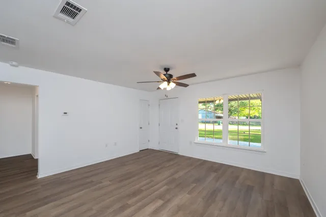 wooden floor in an empty room with a window