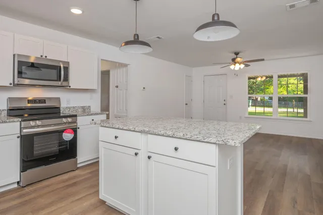 a kitchen with stainless steel appliances granite countertop a stove a sink and a refrigerator
