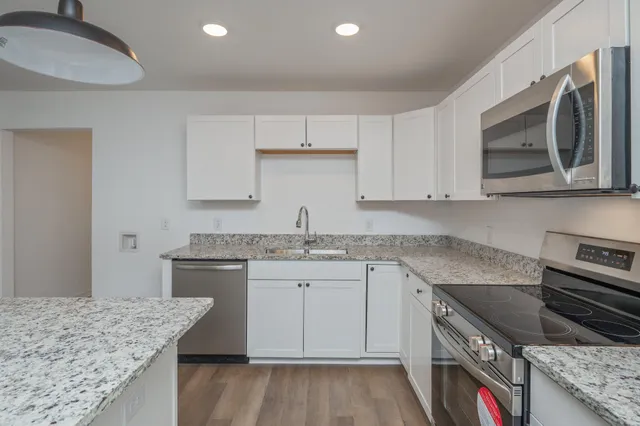 a kitchen with stainless steel appliances granite countertop a sink stove and cabinets