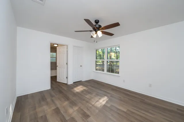 an empty room with a window and a fan