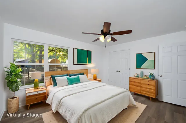 a bedroom with a bed a window and potted plant