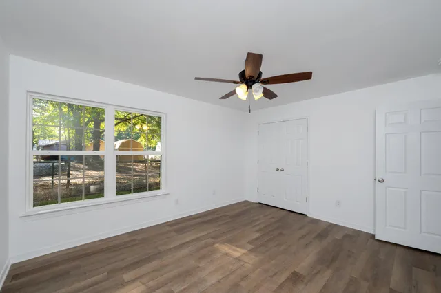 a view of a livingroom with a window and wooden floor