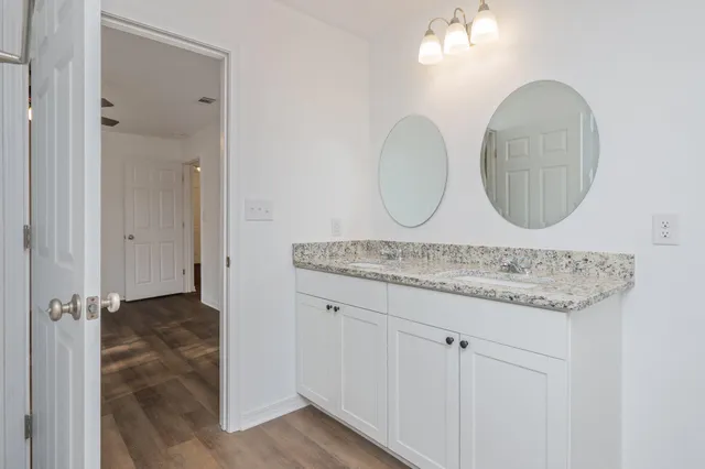 a bathroom with a granite countertop sink and a mirror