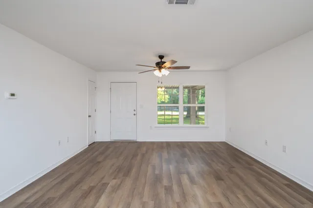 wooden floor in an empty room with a window