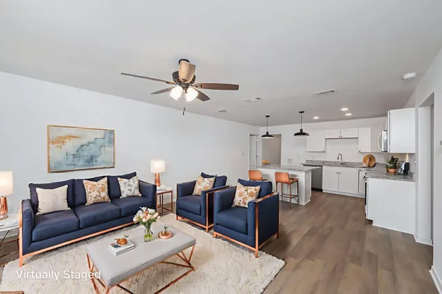 a living room with lots of furniture and kitchen view