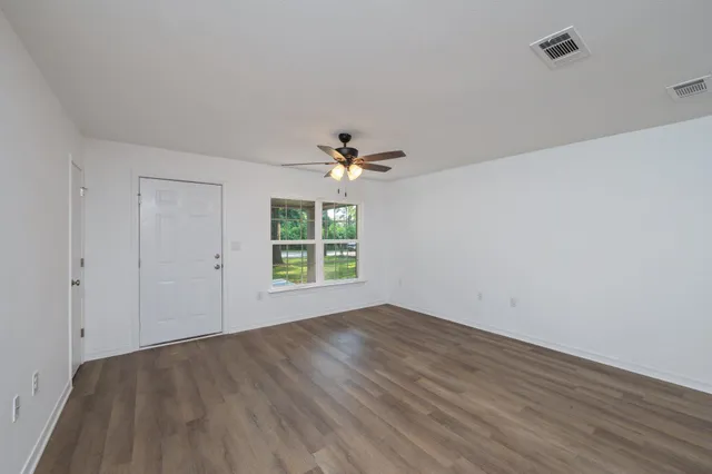 wooden floor in an empty room with a window
