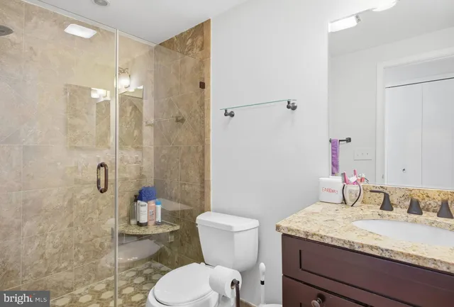 a bathroom with a granite countertop sink toilet and shower