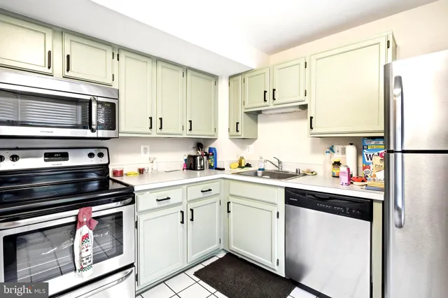 a kitchen with stainless steel appliances a stove a sink and cabinets