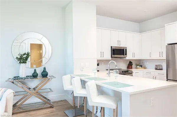 a kitchen with stainless steel appliances a sink a table and chairs
