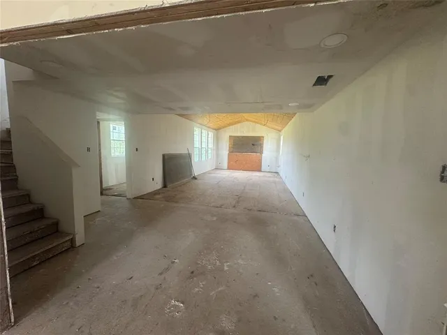 a view of a big room with wooden floor and windows