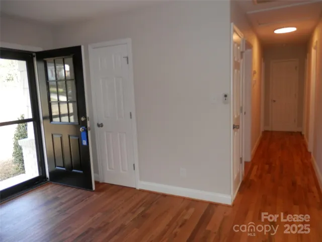 a view of a hallway with wooden floor and stairs