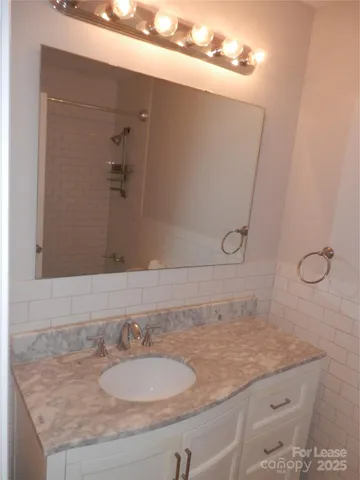 a bathroom with a granite countertop sink and mirror