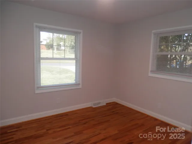 an empty room with wooden floor and a window