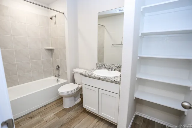 a bathroom with a granite countertop toilet a sink and a bathtub