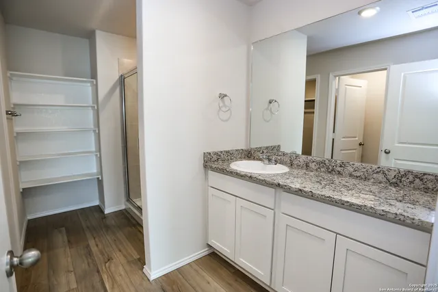 a bathroom with a granite countertop sink and a mirror