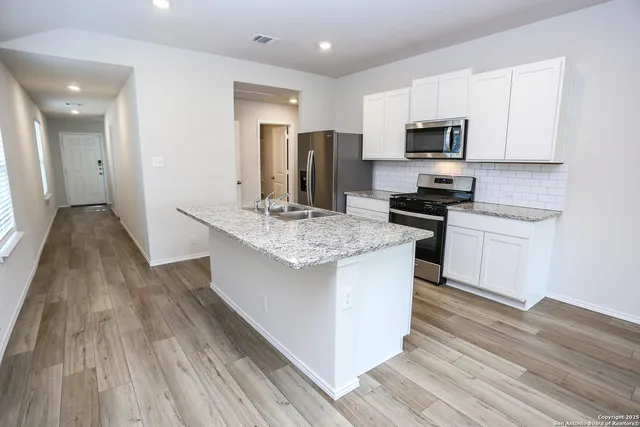 a kitchen with stainless steel appliances granite countertop a sink stove and refrigerator