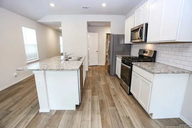 a kitchen with a sink stove and refrigerator