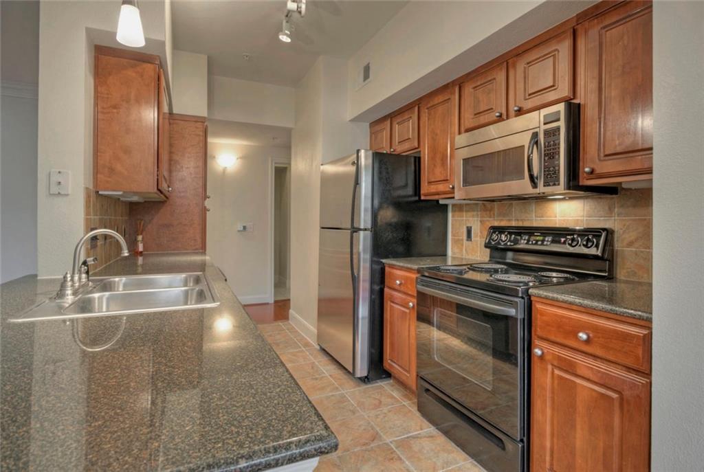 7701 Rialto Boulevard, Unit 1326 Austin, TX 78735 - Photo 5 of 11 a kitchen with stainless steel appliances granite countertop a sink stove and refrigerator