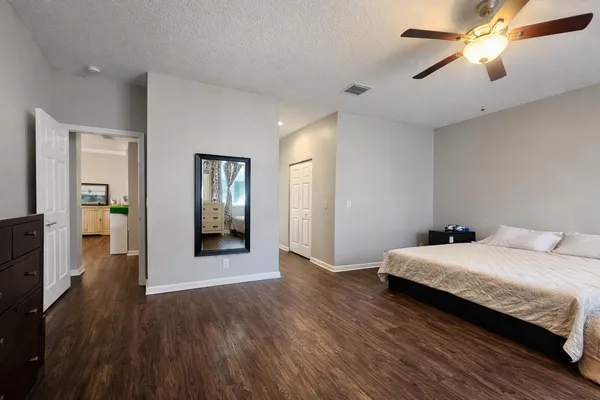 a bedroom with a bed and wooden floor