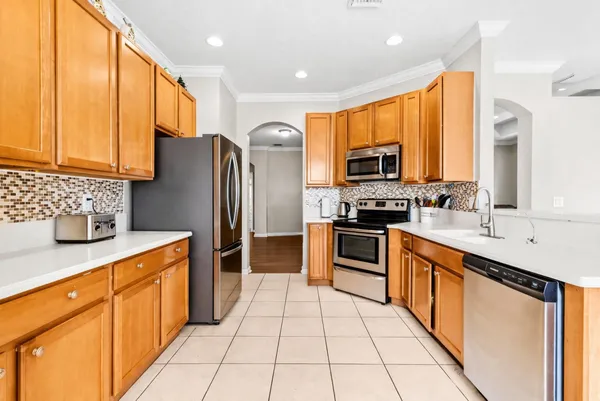 a large kitchen with stainless steel appliances granite countertop a stove a sink and a microwave