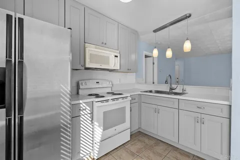 a kitchen with white cabinets and white appliances