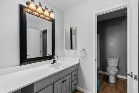 a bathroom with a toilet sink and mirror
