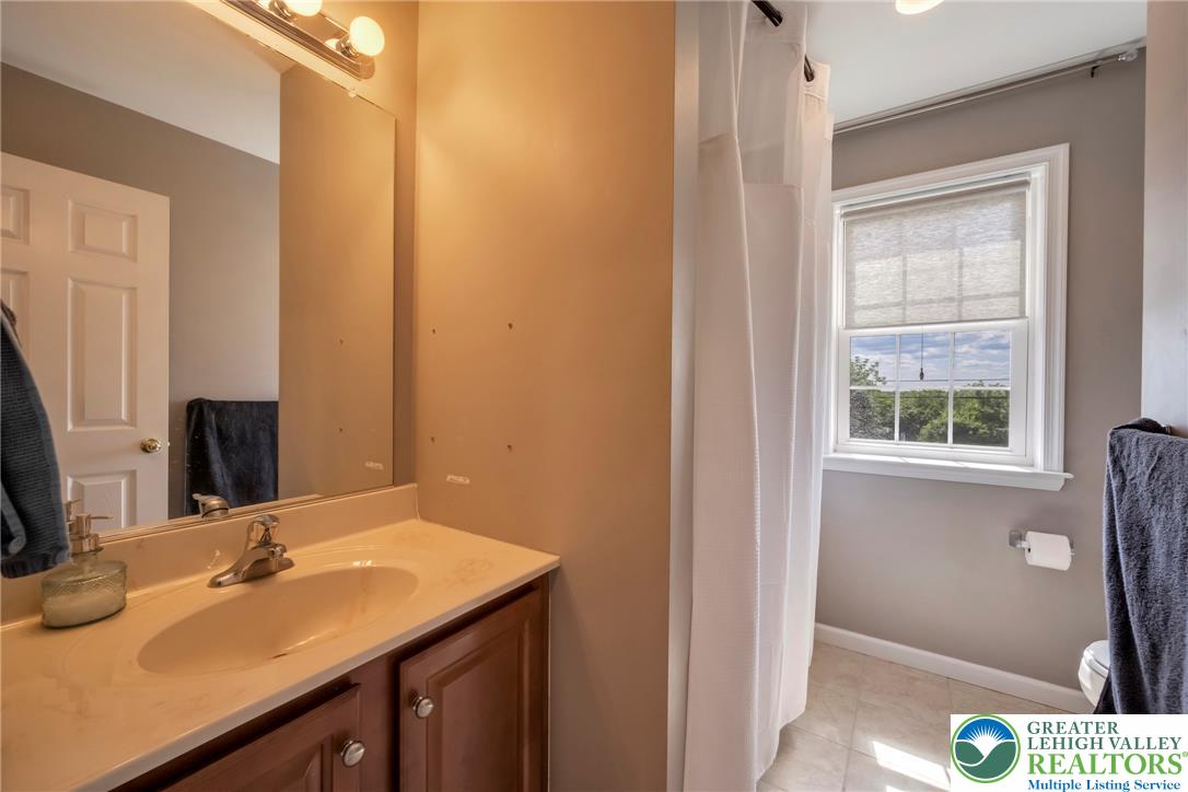 204 Bushkill Ridge Road Wind Gap, PA 18091 - Photo 33 of 48 A well-lit bathroom with a clean vanity, bright mirror, and natural light streaming through the window.