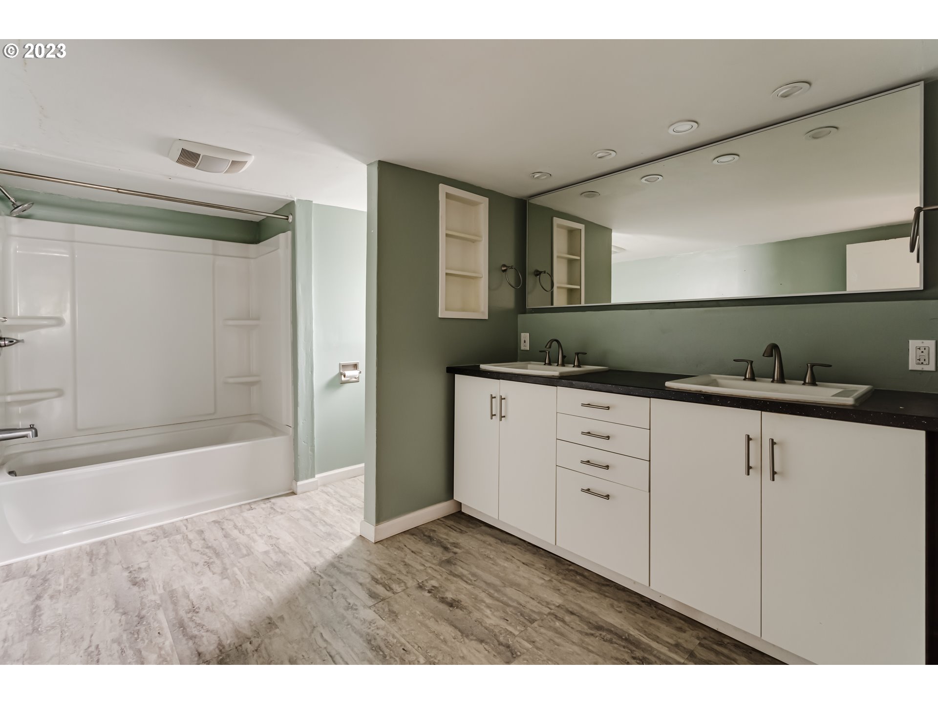 1163 D Street Springfield, OR 97477 - Photo 22 of 37 a bathroom with a granite countertop sink a mirror and a bathtub