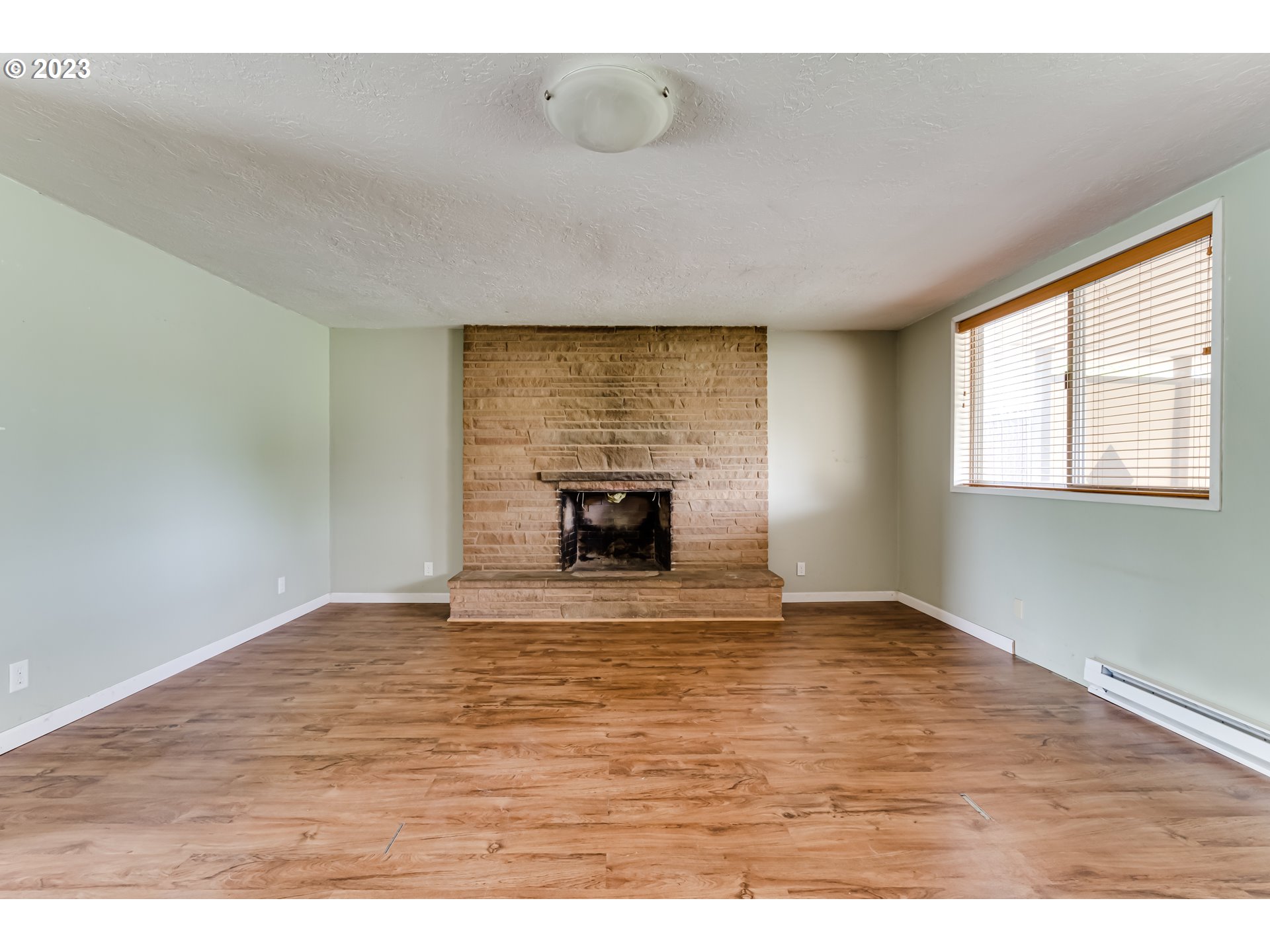 1163 D Street Springfield, OR 97477 - Photo 6 of 37 a view of an empty room with a window and wooden floor