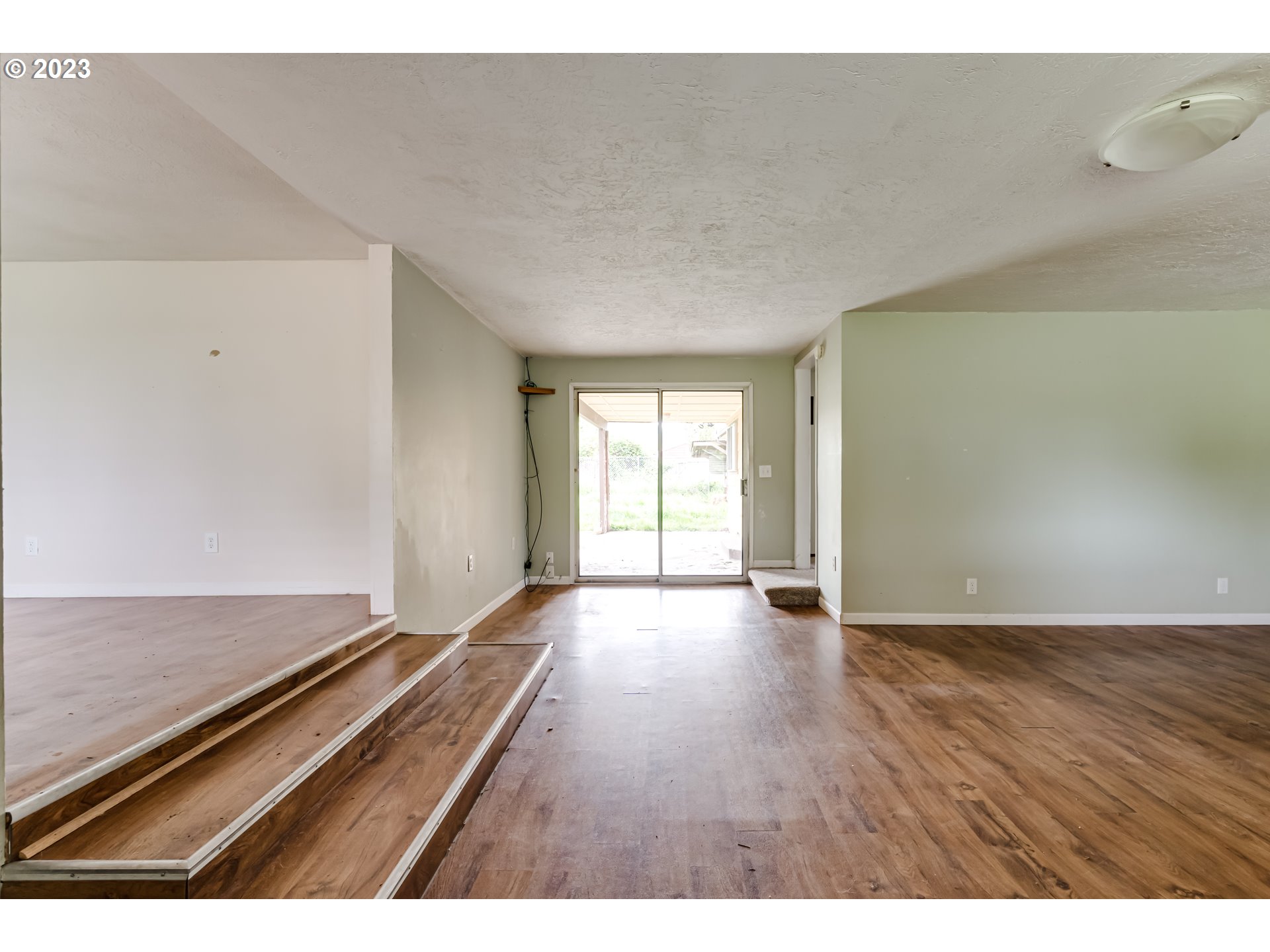 1163 D Street Springfield, OR 97477 - Photo 8 of 37 a view of an empty room with wooden floor and a window