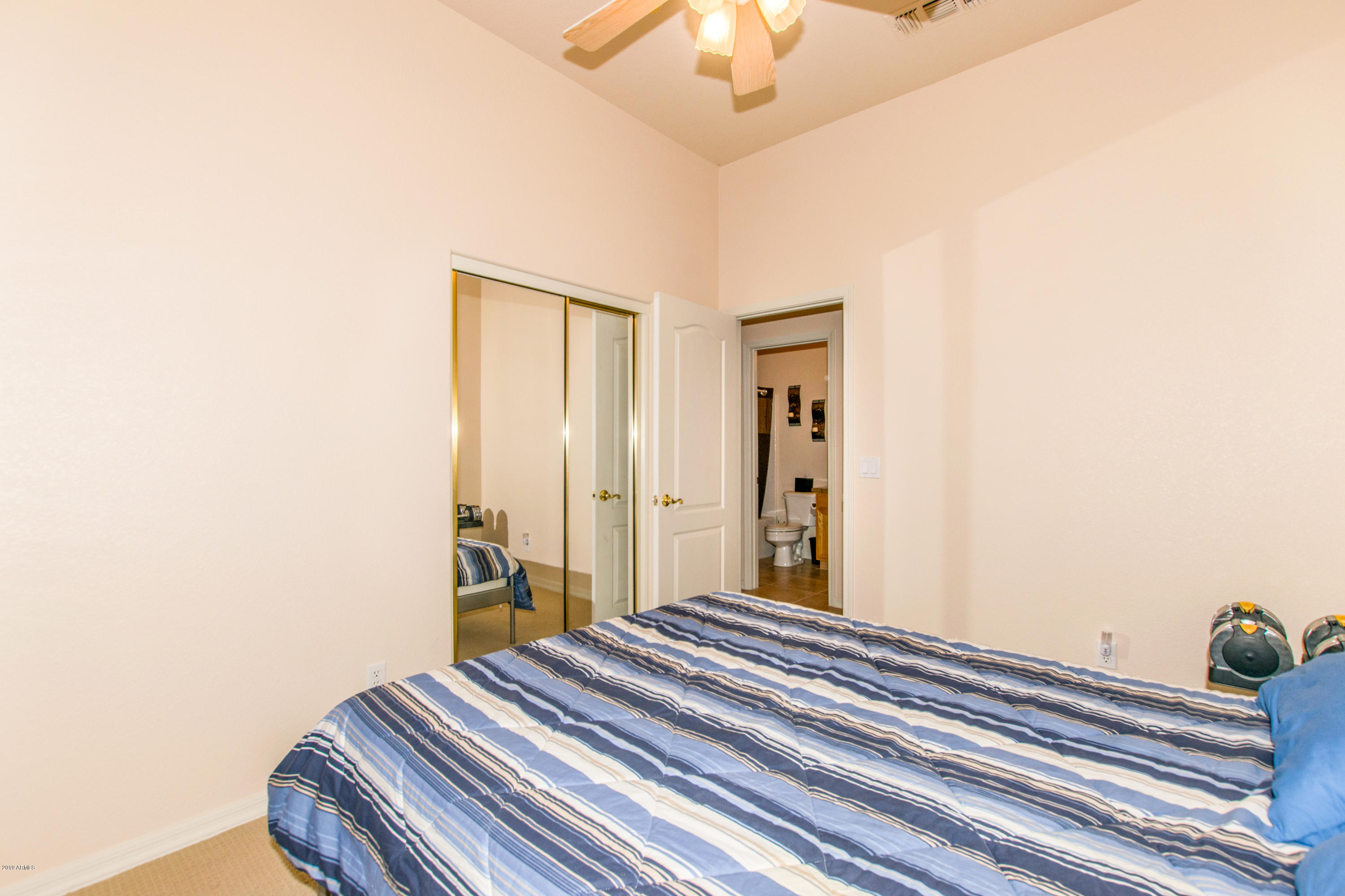 4291 South Strong Box Road Gold Canyon, AZ 85118 - Photo 18 of 27 a bedroom with a bed and a chandelier