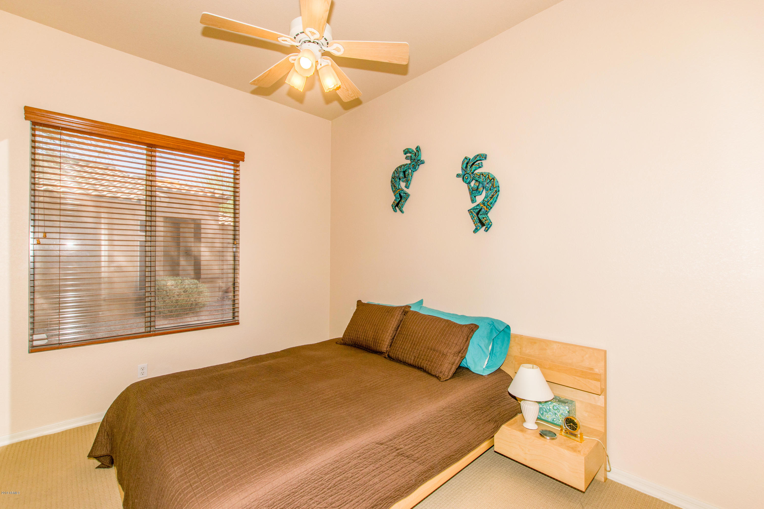 4291 South Strong Box Road Gold Canyon, AZ 85118 - Photo 19 of 27 a bed sitting in a bedroom next to a window