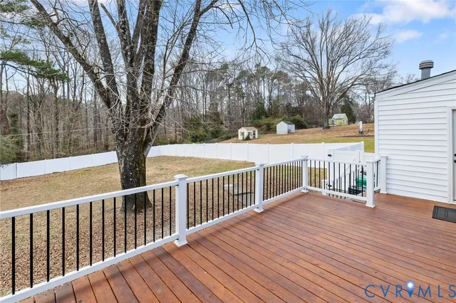 a view of a deck with trees in front of house