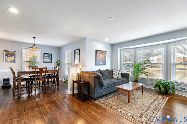 a living room with furniture wooden floor and a window