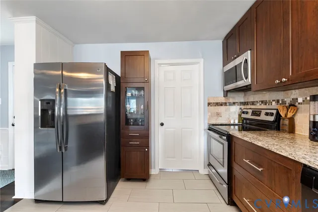 a kitchen with stainless steel appliances granite countertop a refrigerator a stove and a sink with wooden floor