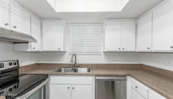 a kitchen with a sink stove and cabinets